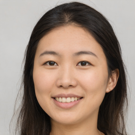 Joyful asian young-adult female with long  brown hair and brown eyes