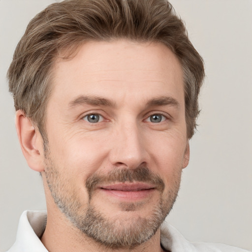 Joyful white adult male with short  brown hair and grey eyes