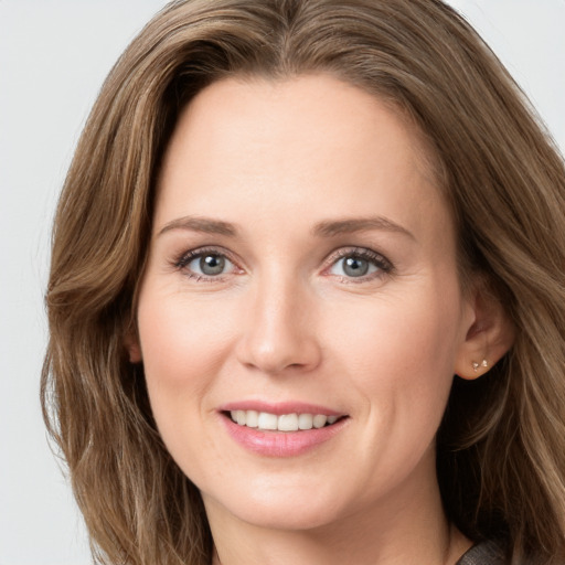 Joyful white young-adult female with long  brown hair and green eyes