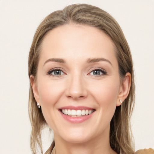 Joyful white young-adult female with long  brown hair and grey eyes