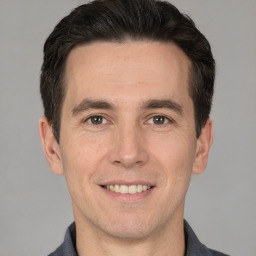 Joyful white adult male with short  brown hair and brown eyes