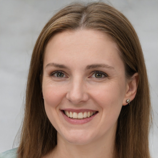 Joyful white young-adult female with long  brown hair and grey eyes