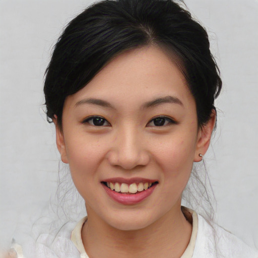 Joyful asian young-adult female with medium  brown hair and brown eyes