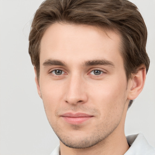 Joyful white young-adult male with short  brown hair and grey eyes