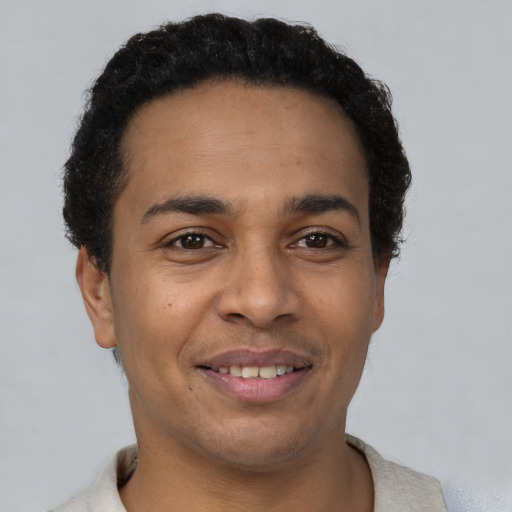 Joyful latino young-adult male with short  brown hair and brown eyes