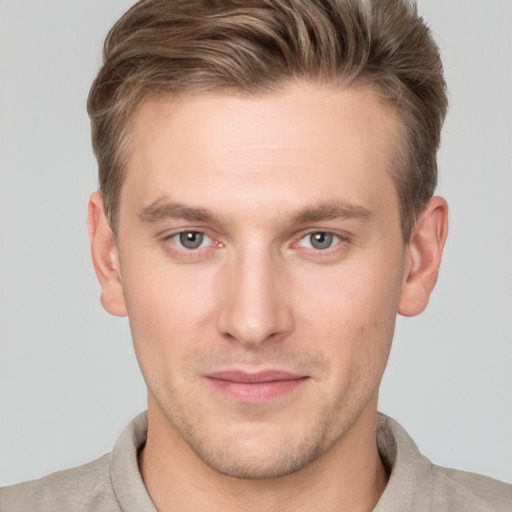 Joyful white young-adult male with short  brown hair and grey eyes