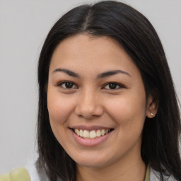 Joyful latino young-adult female with long  brown hair and brown eyes