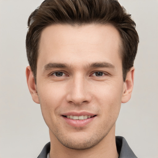 Joyful white young-adult male with short  brown hair and grey eyes