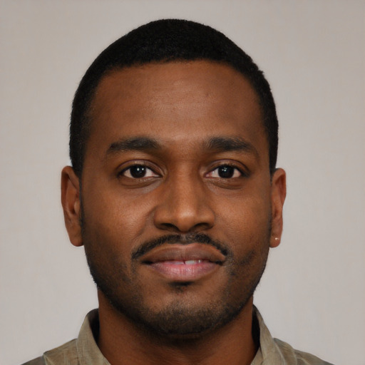 Joyful black young-adult male with short  brown hair and brown eyes