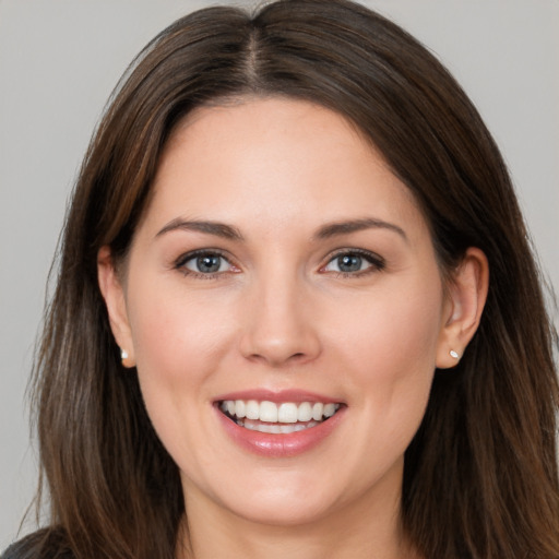 Joyful white young-adult female with long  brown hair and brown eyes