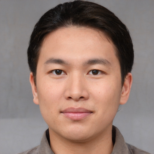 Joyful asian young-adult male with short  brown hair and brown eyes