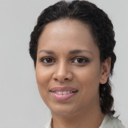 Joyful black young-adult female with long  brown hair and brown eyes