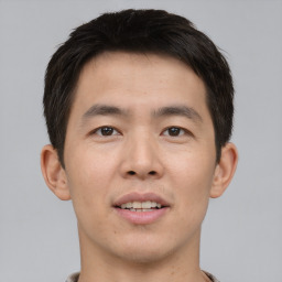 Joyful asian young-adult male with short  brown hair and brown eyes