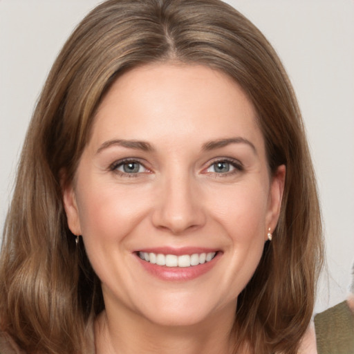 Joyful white young-adult female with medium  brown hair and grey eyes