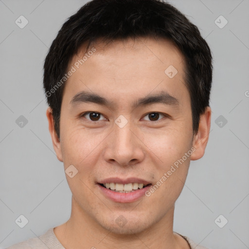 Joyful asian young-adult male with short  brown hair and brown eyes