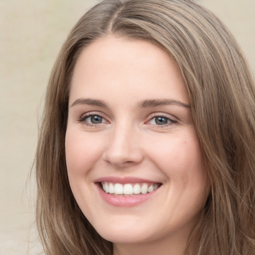 Joyful white young-adult female with long  brown hair and grey eyes