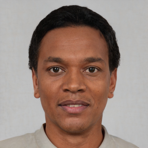 Joyful black adult male with short  black hair and brown eyes