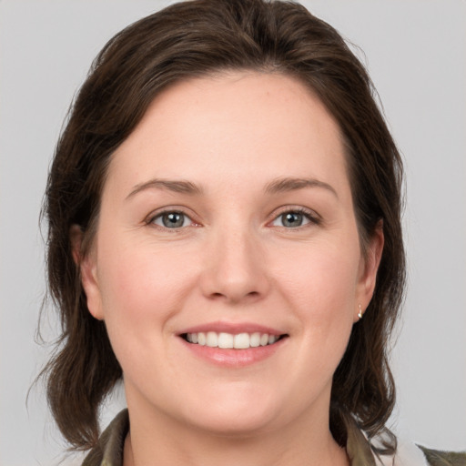 Joyful white young-adult female with medium  brown hair and grey eyes