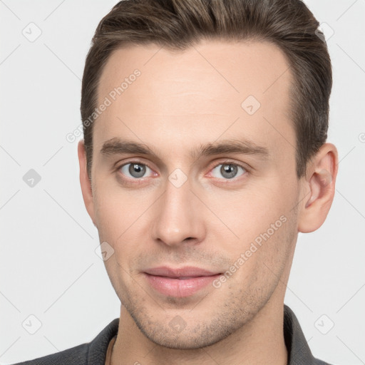 Joyful white young-adult male with short  brown hair and grey eyes