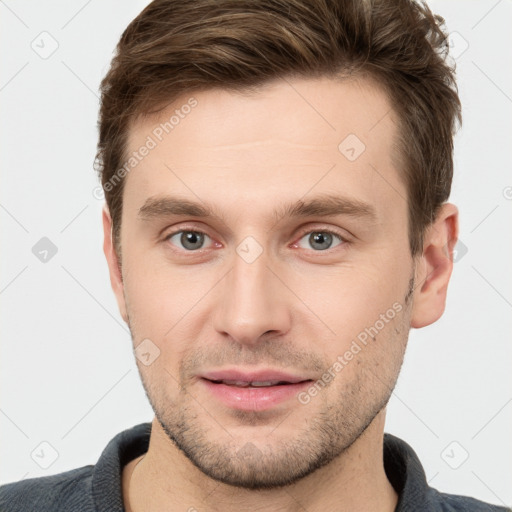 Joyful white young-adult male with short  brown hair and grey eyes