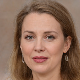 Joyful white adult female with long  brown hair and grey eyes