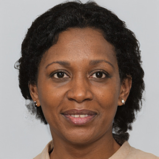 Joyful black adult female with short  black hair and brown eyes