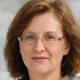 Joyful white adult female with medium  brown hair and blue eyes