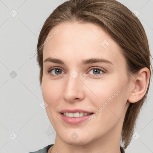 Joyful white young-adult female with medium  brown hair and grey eyes