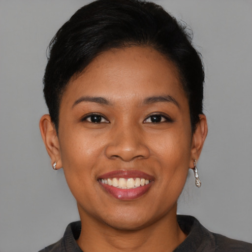 Joyful latino young-adult female with short  brown hair and brown eyes