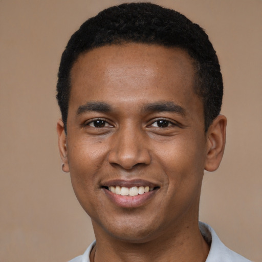 Joyful black young-adult male with short  black hair and brown eyes
