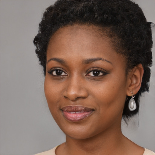 Joyful black young-adult female with medium  black hair and brown eyes