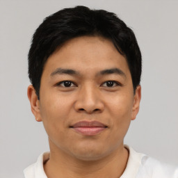 Joyful latino young-adult male with short  black hair and brown eyes