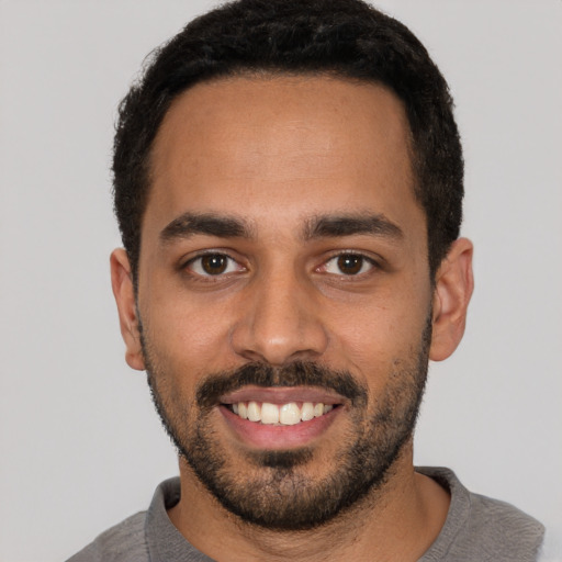 Joyful latino young-adult male with short  black hair and brown eyes