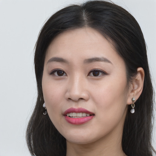 Joyful asian young-adult female with long  brown hair and brown eyes