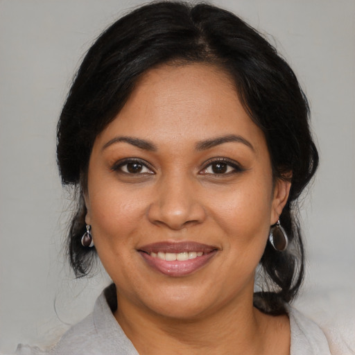 Joyful latino adult female with medium  brown hair and brown eyes