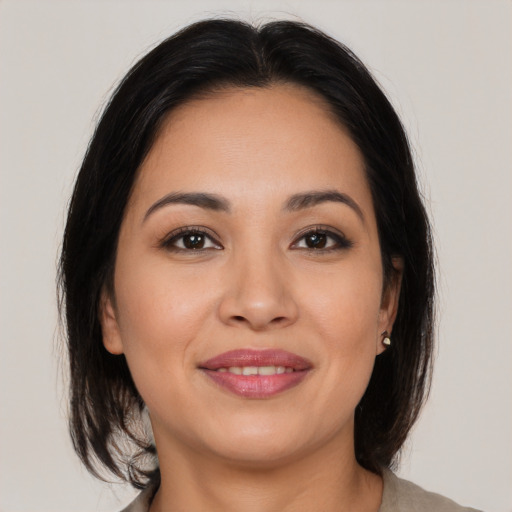 Joyful latino young-adult female with medium  brown hair and brown eyes