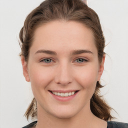 Joyful white young-adult female with long  brown hair and blue eyes