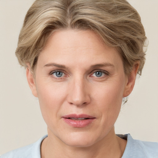 Joyful white adult female with short  blond hair and grey eyes