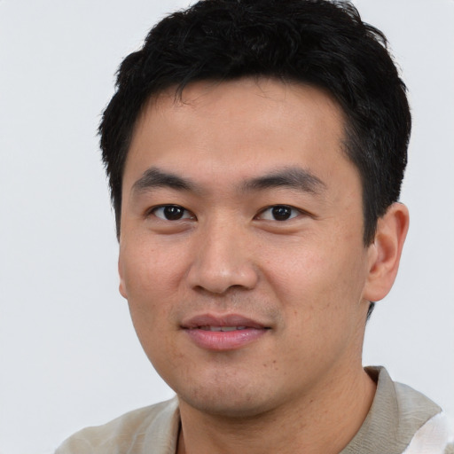 Joyful asian young-adult male with short  black hair and brown eyes