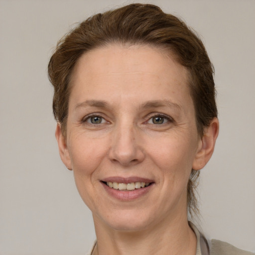 Joyful white adult female with short  brown hair and grey eyes