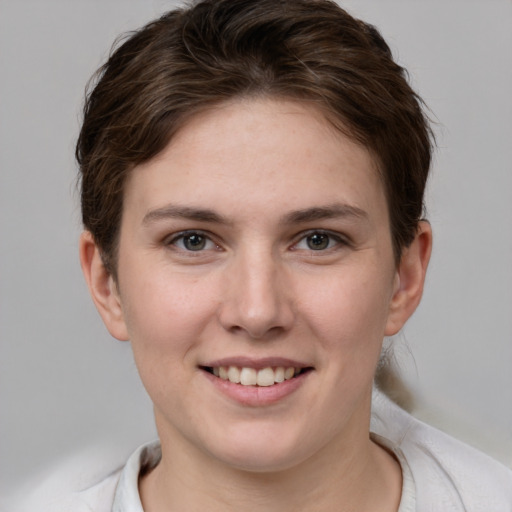 Joyful white young-adult female with short  brown hair and grey eyes