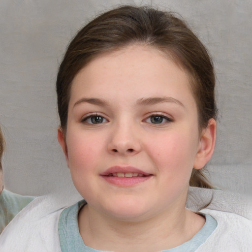 Joyful white child female with short  brown hair and blue eyes