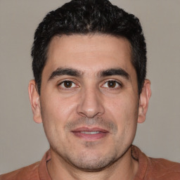 Joyful white young-adult male with short  black hair and brown eyes