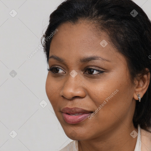 Joyful black young-adult female with long  brown hair and brown eyes