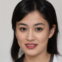 Joyful asian young-adult female with medium  black hair and brown eyes