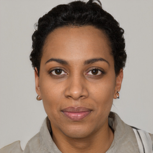 Joyful black young-adult female with short  black hair and brown eyes