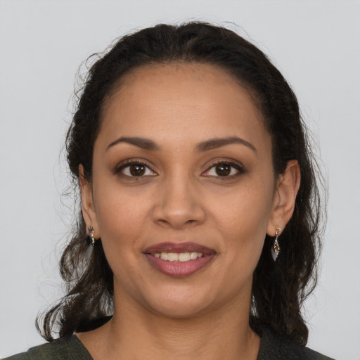 Joyful latino young-adult female with medium  brown hair and brown eyes