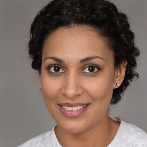 Joyful black young-adult female with short  brown hair and brown eyes
