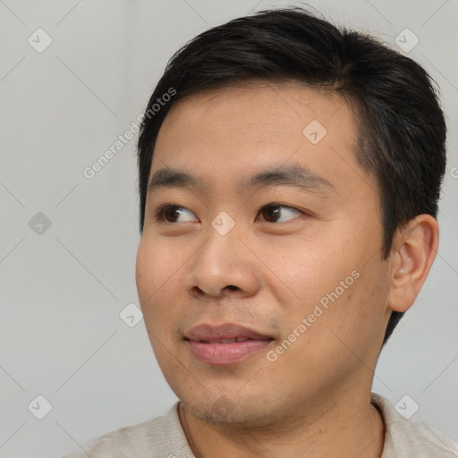 Joyful asian young-adult male with short  black hair and brown eyes