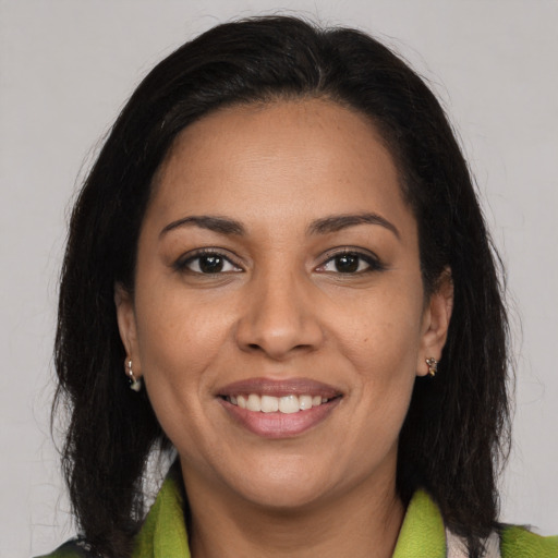 Joyful latino young-adult female with medium  brown hair and brown eyes